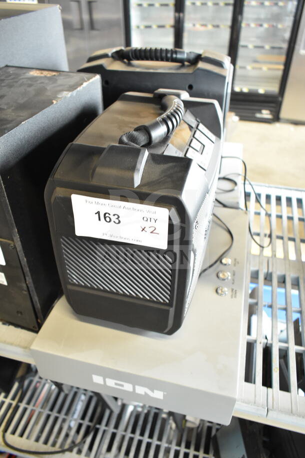 Two Ion speakers with robust design, carrying handles, and visible tag indicating auction lot 163, quantity 2.