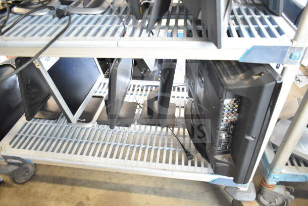 Five various monitors including Dell and Sanyo, mixed models, on a metal cart. Good condition, sold as a set.