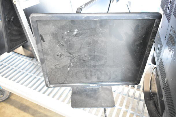 Five assorted monitors, including Dell and Sanyo. Visible dust and wear on screens. "Dell" label on one monitor base.