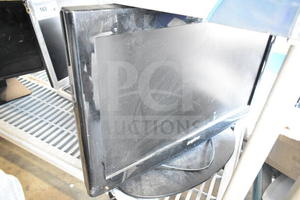 Five various monitors including Dell and Sanyo models, displayed on a shelf. Condition appears used, with visible dust.