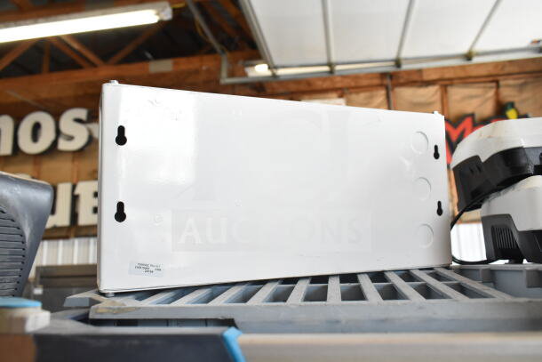 White emergency sign back panel, rectangular shape, with mounting holes and label indicating model 1500002 Rev E1.