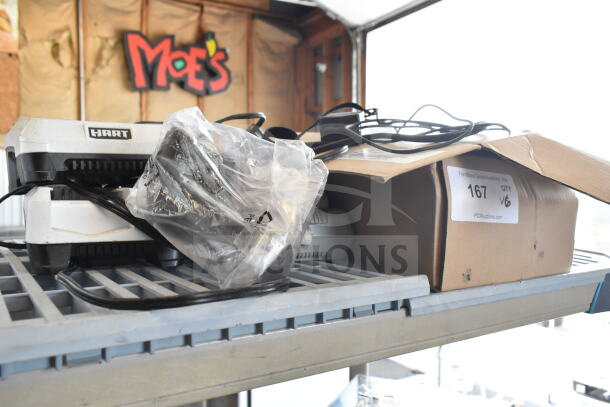 6 various items including Hart CGH006 battery charger, barcode scanner, UCL172-4 quad charger on shelf, labeled box.