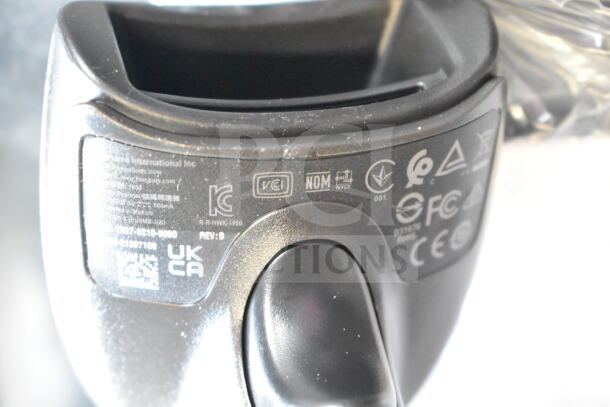 Close-up of a device showing regulatory labels and markings, including UKCA and CE certifications. Part of an auction lot with a Hart CGH006 Battery Charger, Barcode Scanner, UCL172-4 Quad Charger.