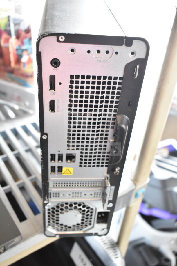 Back view of HP computer tower showing HDMI, USB, Ethernet ports, and ventilation. Black and silver casing, lightly used.