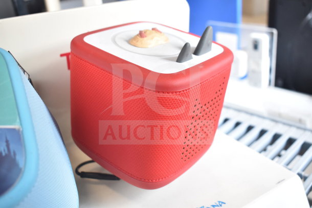 Red Toniebox from store display, features textured surface and dual ears. Excellent condition. Includes accompanying blue box.