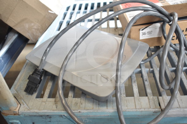 Sensormatic ZBSMPCPEF with cable, gray, on a blue metal surface; condition appears used. Box labeled "346-1557".