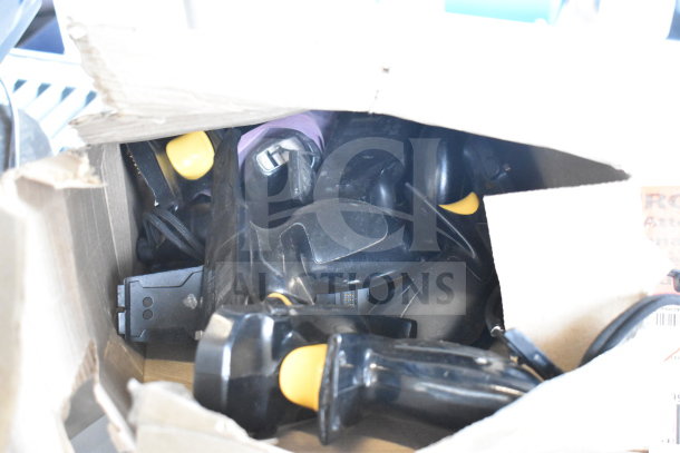 Box of miscellaneous items including Sensormatic ZBSMPCPEF parts; visible yellow handles, and cords; general wear.