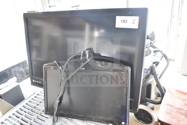 Two monitors, brands: AOC and Funai. Monitors appear used with visible cables. Auction tag indicates item 182, quantity 2.