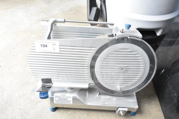 Edlund EDV-12 commercial meat slicer with blade sharpener; carriage needs reattachment; 120V, 1 phase; auction tag 194 visible.