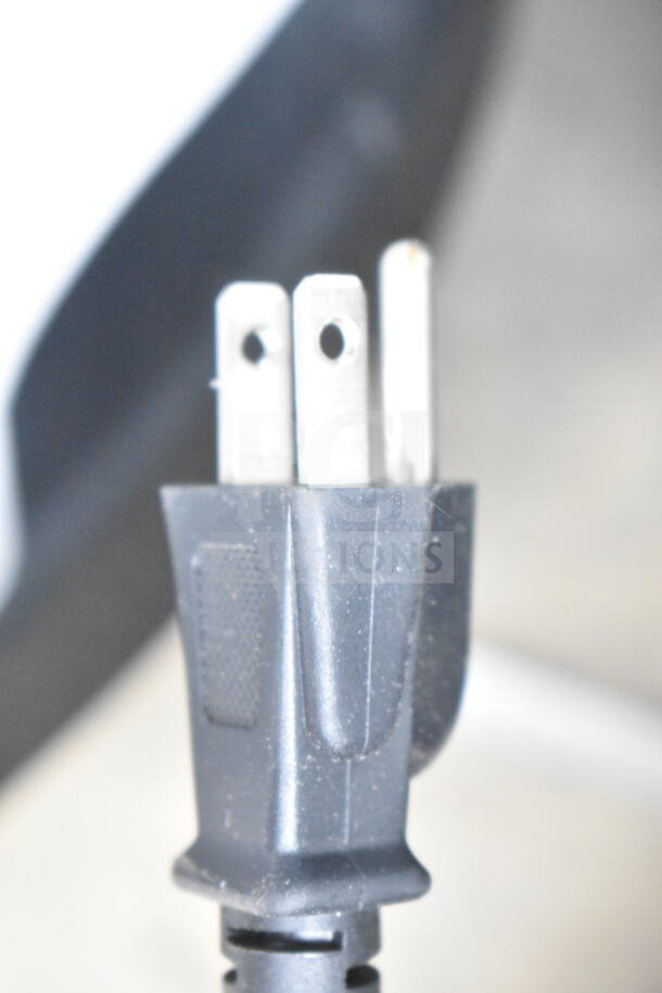 Close-up of a three-prong electric plug connected to Edlund EDV-12 commercial meat slicer. Carriage needs reattachment.