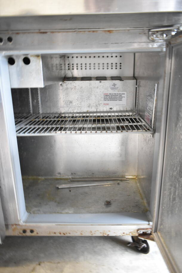Continental SW48N12M Prep Table interior showing wire shelving and refrigeration unit, some wear visible, on casters.