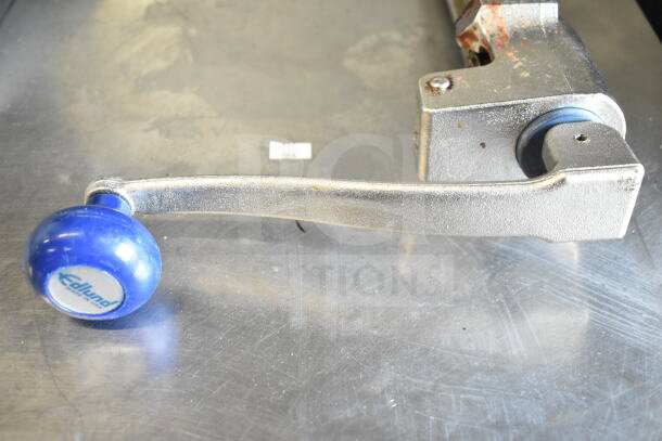 Edlund commercial can opener with a blue handle, metallic finish, some wear. Visible label indicates brand.