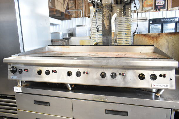 Garland commercial gas-powered countertop griddle with multiple controls, stainless steel finish, in used condition.