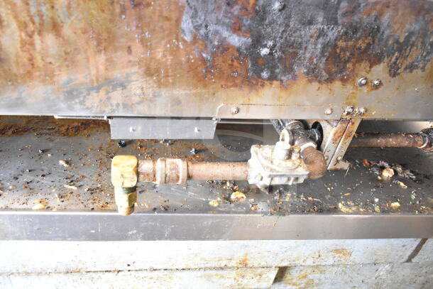 Garland commercial gas griddle with stainless steel flat top, showing visible rust and wear. Used condition.