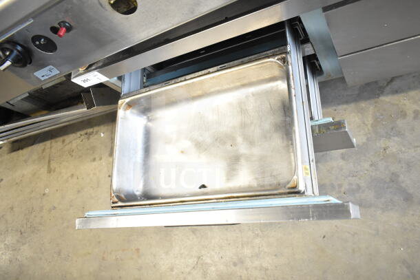 Delfield commercial 4-drawer chef base with stainless steel construction, visible wear, on commercial casters, 115V, 1 phase.
