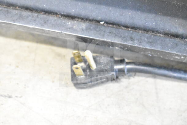 Power plug for True GDM-23 cooler. 115 volts, 1 phase. Visible wear on the plug and floor surface.