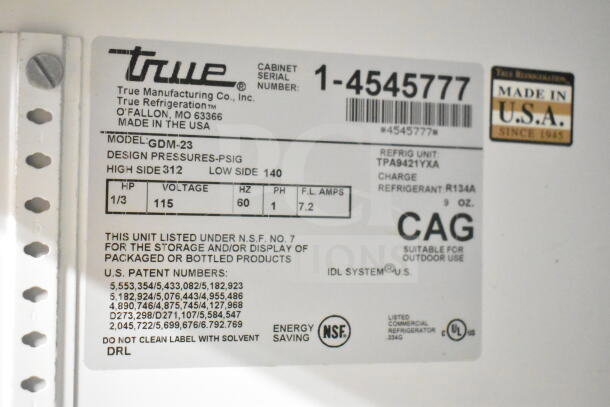 True GDM-23 cooler label showing model, voltage 115V, phase 1, and design pressures. Made in USA tag visible.