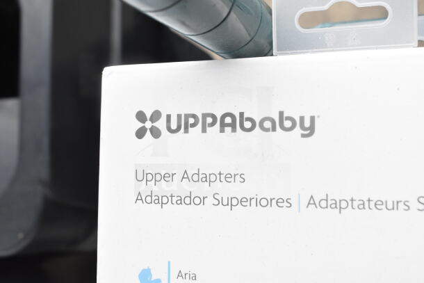 Uppababy Upper Adapters, new condition, box labeled in multiple languages. Includes two adapters, some scratch and dent marks visible.