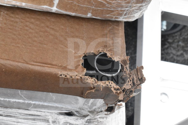 Damaged packaging revealing metal frame, part of a set including shelf and work table. Items are new but scratch and dent.
