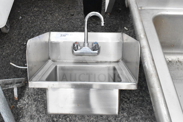 Commercial single bay sink with faucet, dual handles, and side splash guards. Stainless steel, used condition.