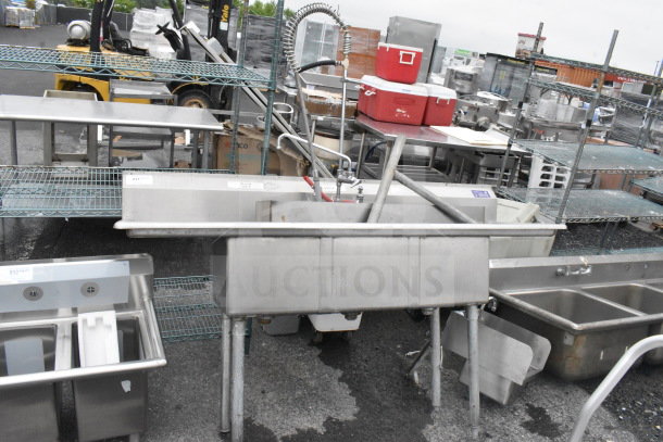Commercial 3 bay stainless steel sink with dual drain boards, faucet, and spray nozzle attachment; used condition.