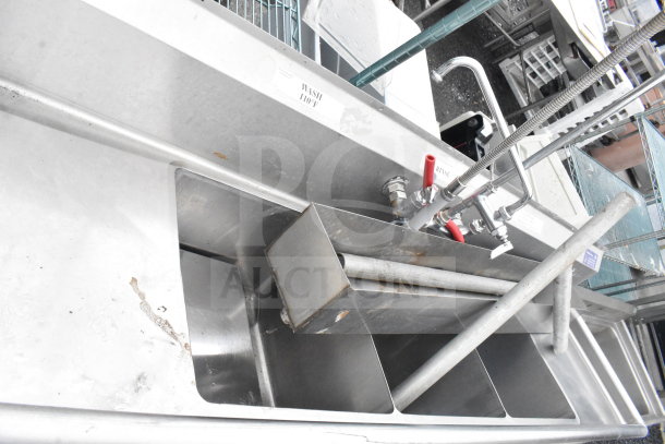 Commercial 3 bay stainless steel sink with dual drain boards, faucet, and spray nozzle. Marking shows "Wash 110°F".
