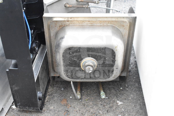 Commercial single bay wall mount sink with faucet, handles, and side splash guard in used condition.
