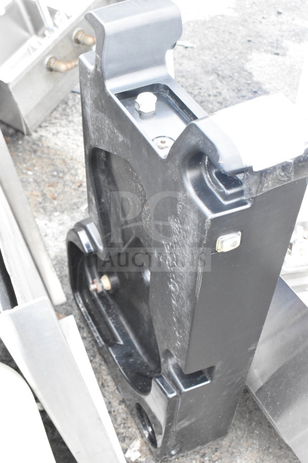 Black unit with rugged surface, part of auction with tabletop; sturdy build, metallic connectors visible. 