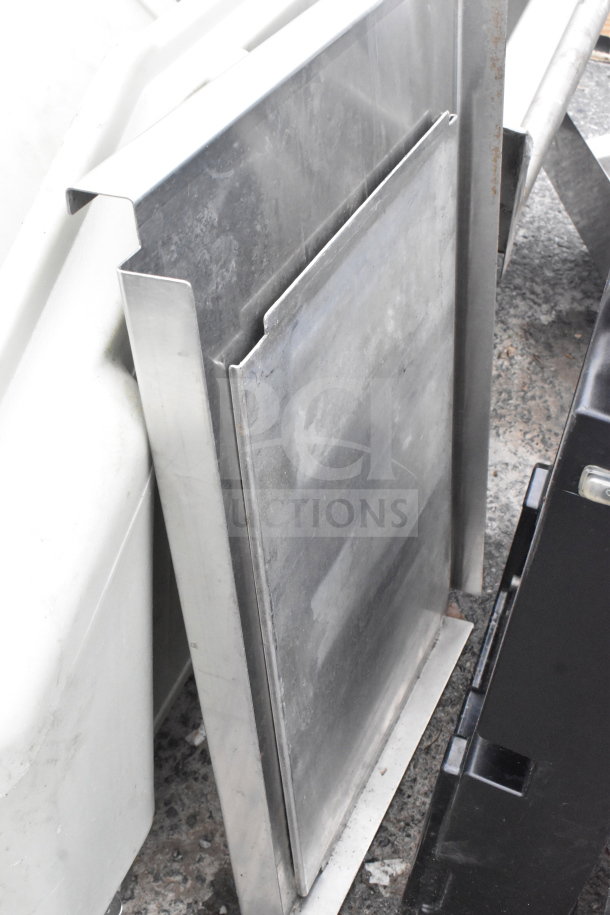Two items include a metal tabletop and a black unit. Both appear sturdy with visible wear, ideal for multipurpose use.