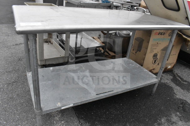 Commercial stainless steel table with under shelf, showing wear, ideal for food service use.