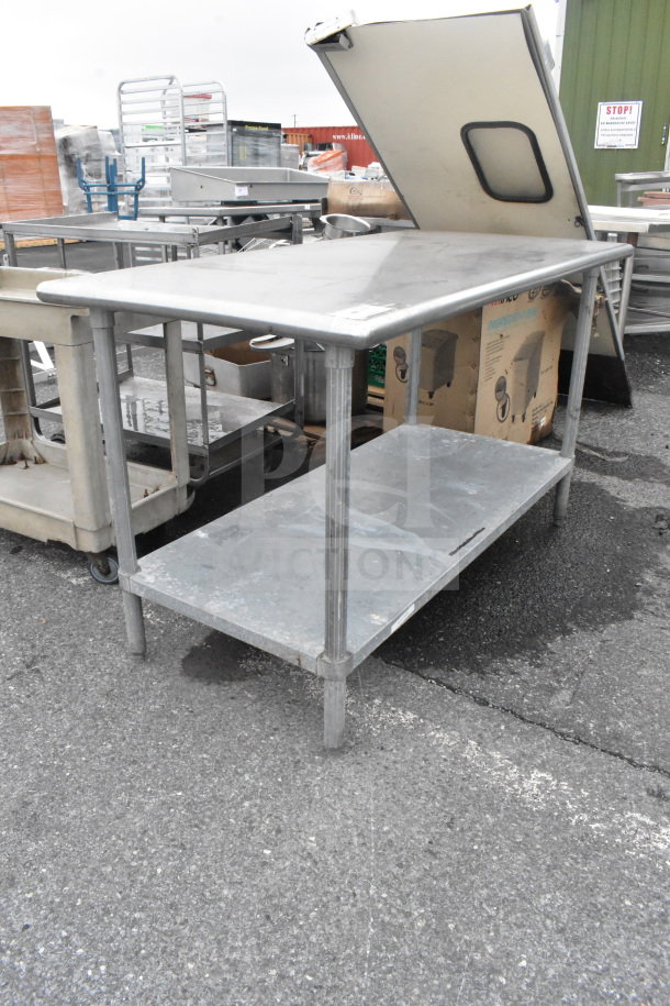 Commercial stainless steel table with under shelf, sturdy legs, used condition, ideal for kitchen or industrial use.