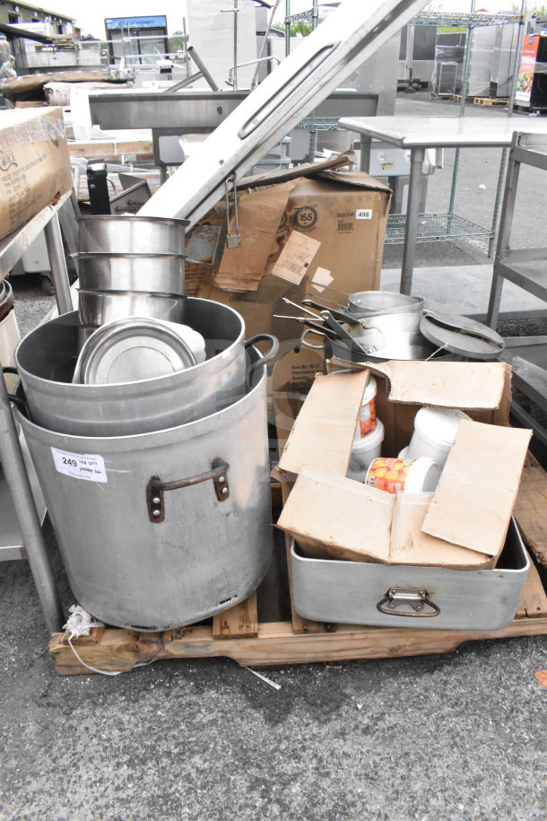 Pallet of various kitchen items including stock pots, drop-in bins, saucepans, utensils, and a fire extinguisher.