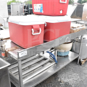 Commercial table with red portable coolers, stainless steel dunnage rack, and a rice cooker; visible wear.