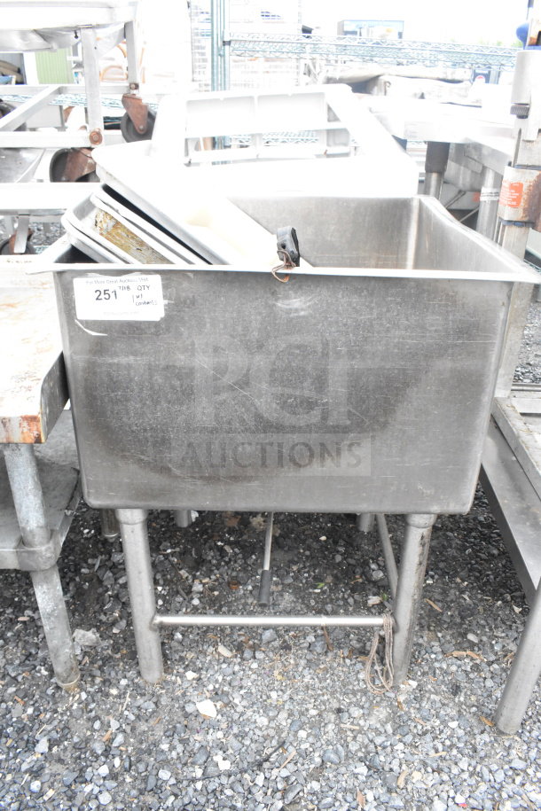 Commercial single bay ice bin with contents including baking pans, stainless steel, used condition. Visible auction label.