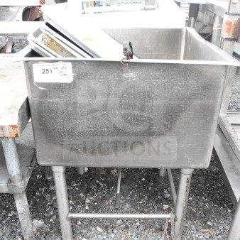Commercial single bay ice bin with contents including baking pans, stainless steel, used condition. Visible auction label.