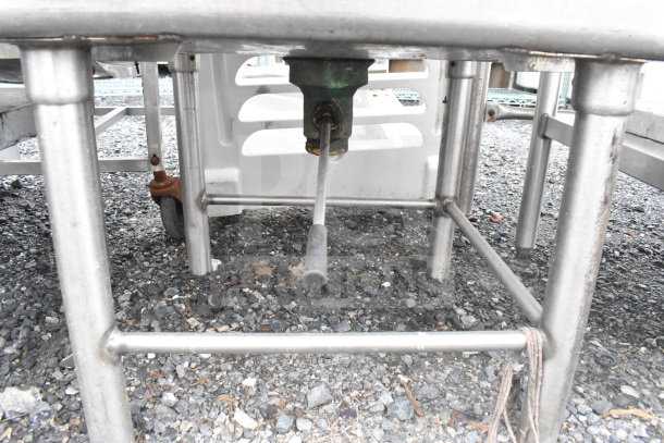 Commercial single bay ice bin with metal frame and baking pans inside. Visible drain pipe and sturdy stainless steel legs.