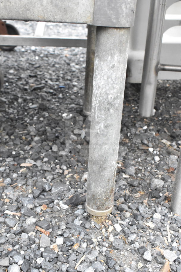 Commercial equipment stand with under shelf and metal legs, suitable for industrial use. Slightly worn condition.