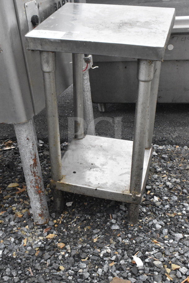 Commercial steel table with under shelf, worn condition; ideal for heavy-duty kitchen use. Rust visible on base legs.