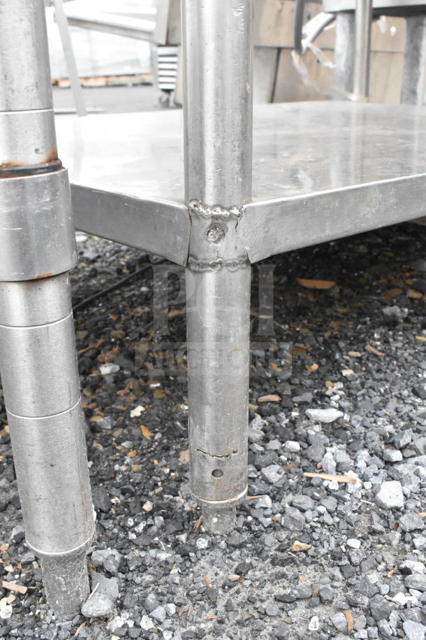 Commercial metal table with drawer and under-shelf. Visible welds; minor rust on legs. Suitable for industrial use.