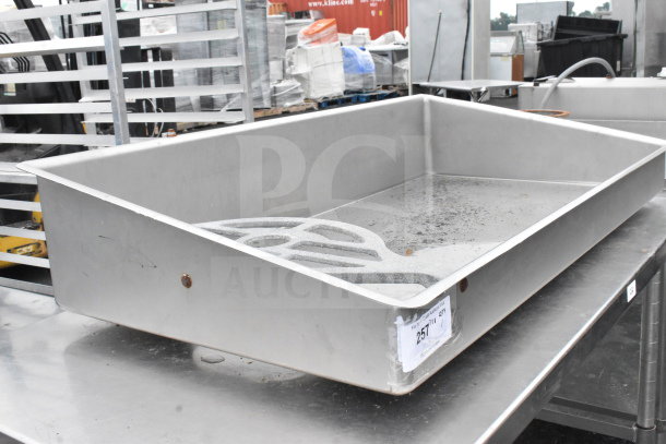 Stainless steel commercial meat grinder tray, rectangular, with slight wear. Visible label reads "257 7/11 QTY."