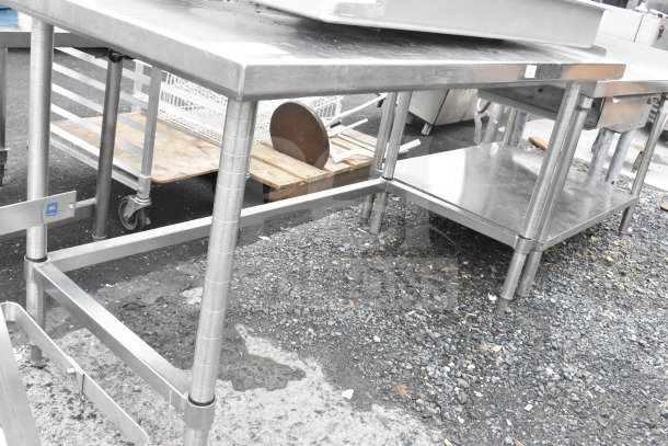 Stainless steel commercial table with adjustable legs, featuring a lower shelf. Used condition with minor surface wear.