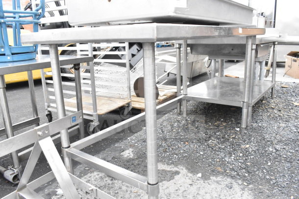 Stainless steel commercial table with sturdy legs and a lower shelf, suitable for industrial use, in used condition.