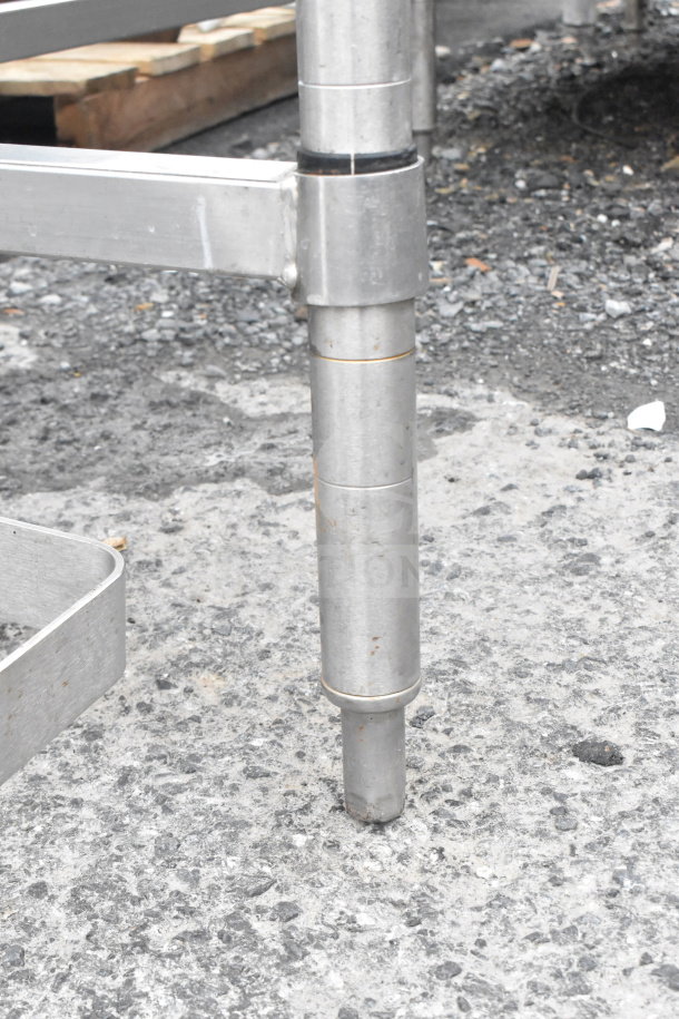 Stainless steel leg of a commercial table in used condition, featuring tubular construction and sturdy design.
