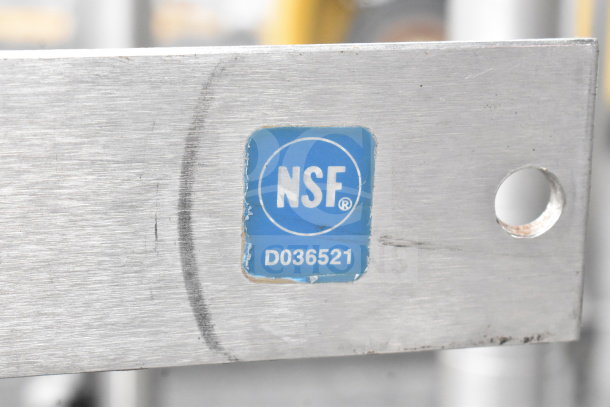 Commercial pot rack with S hooks, made of metal, NSF certified marked "D036521," showing a mounting hole.