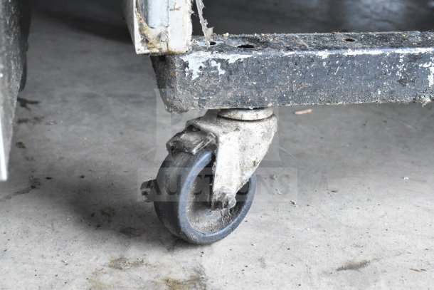 Close-up of a worn caster wheel on the base of a True T-72 Commercial Reach In Cooler. Signs of heavy use and wear.