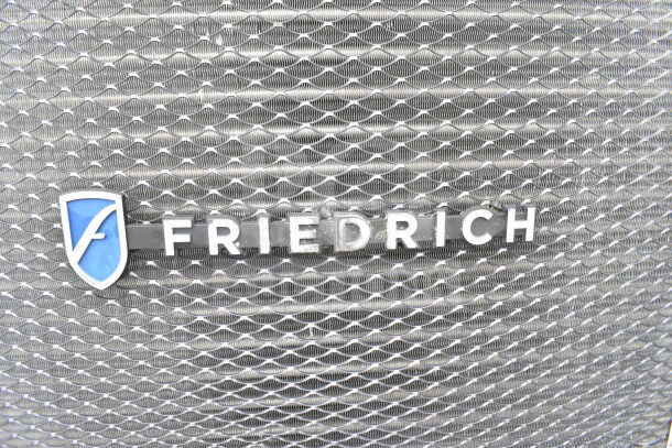 Friedrich KCL24A30B-A 23,000 BTU air conditioner grille with brand logo, metallic finish.