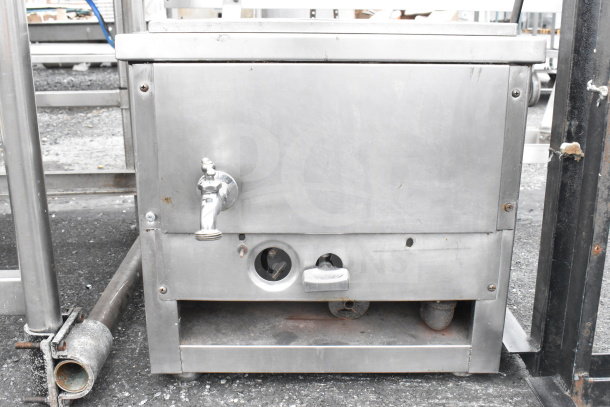 Commercial metal unit with two holes, featuring a faucet on the front. Steel construction, showing signs of use.