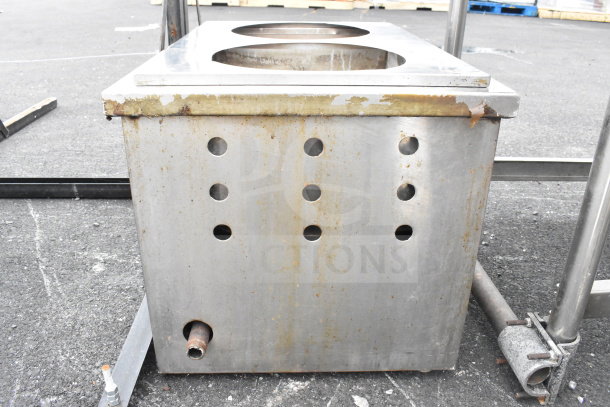 Stainless steel commercial unit with two circular holes and multiple ventilation holes. Surface shows signs of wear.