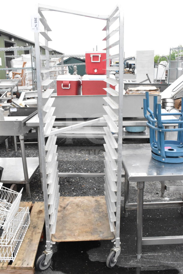 Commercial transport pan rack with multiple shelves on sturdy commercial casters, industrial setting, used condition.