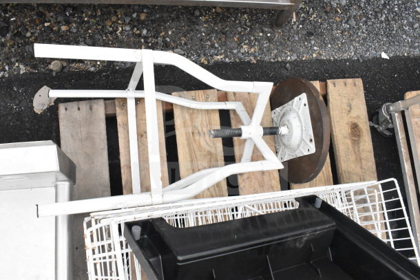 "Assorted items on pallets, including metal frame, baskets, and industrial parts, some wear visible."